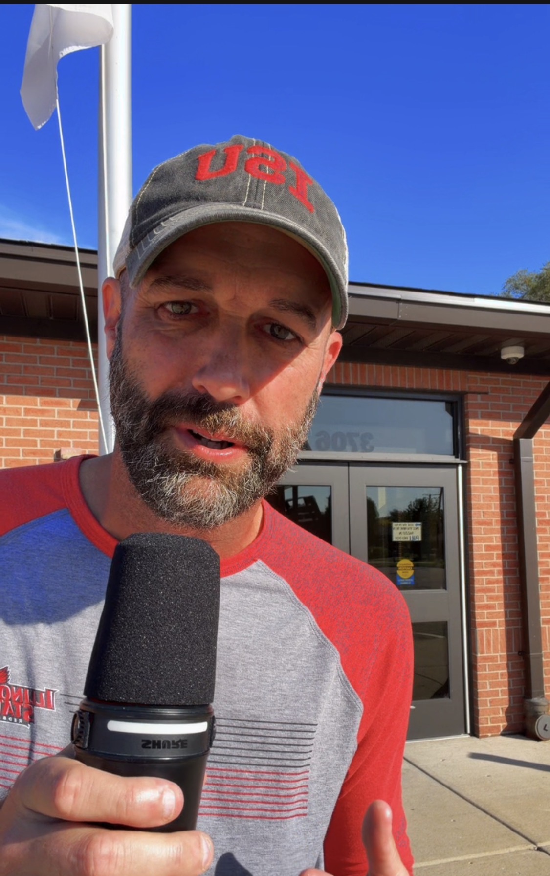 Mike Pope holding a microphone outside Gurnee School District 56 during his October 12 field report