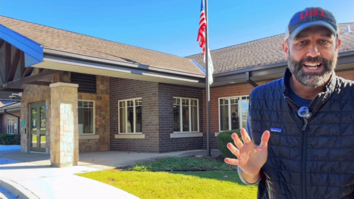 Mike Pope reporting outside a school building, with an American flag nearby